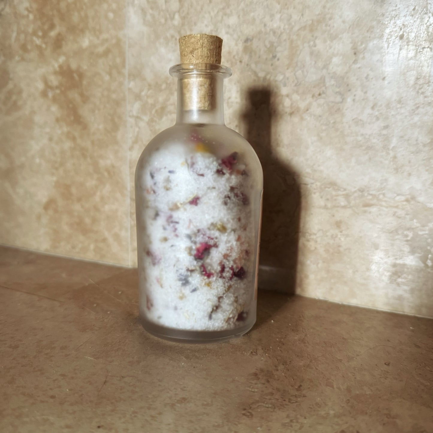 Foot salt soak with Himalayan pink salt, Epsom salt, Dead Sea salt, chamomile, and rose petals for a relaxing foot bath.
